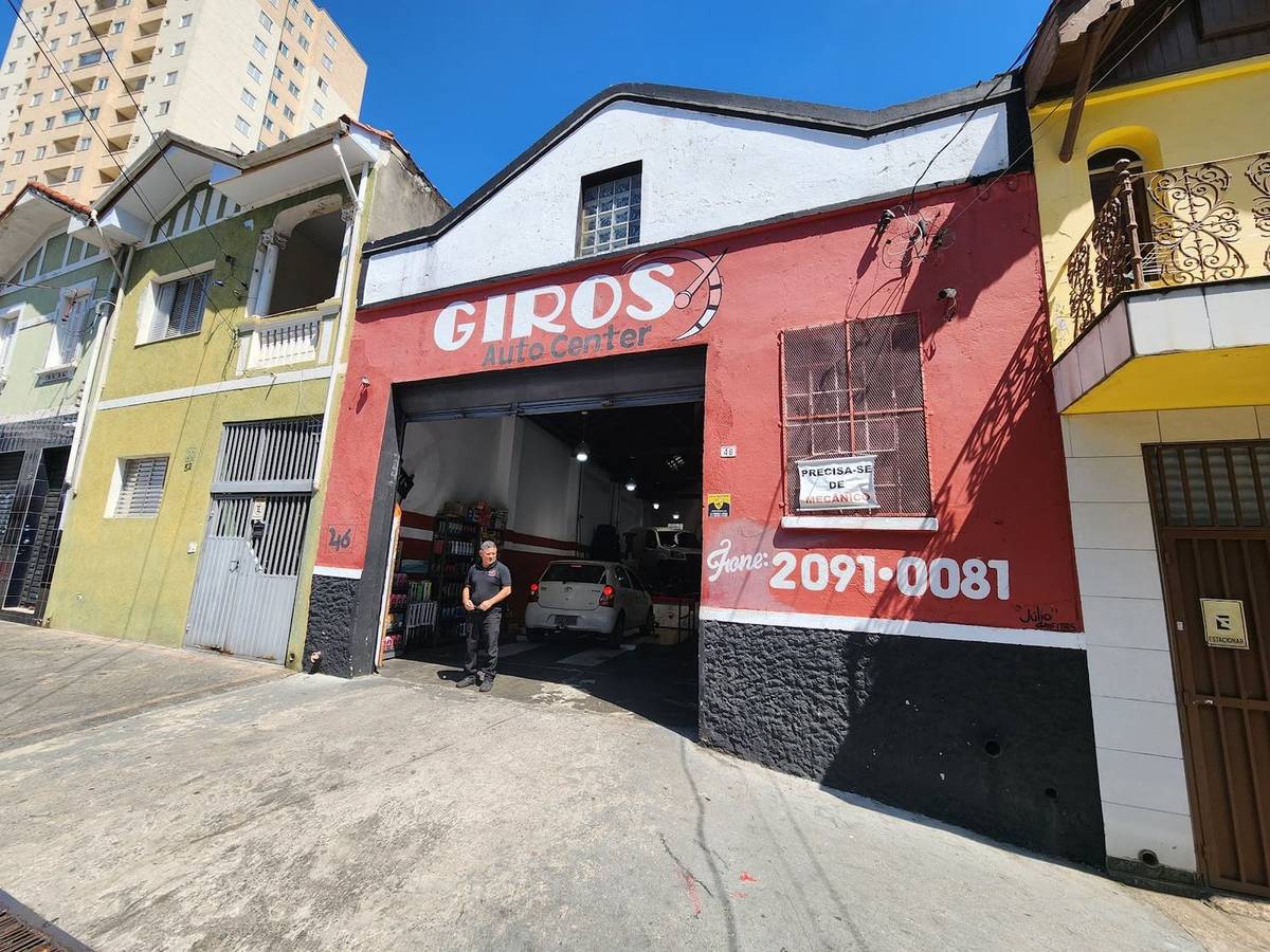 Fachada vermelha do Giros Auto Center na Rua Cândido Vale, com o letreiro GIROS e o telefone pintado na parede