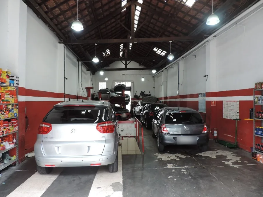 Interior da oficina da Giros, com os carros nos boxes e as prateleiras de peças