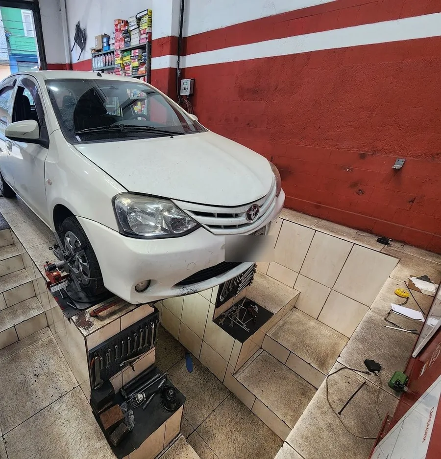 Carro sobre a rampa de alinhamento, com o sensor na roda e a vala de serviço ao lado